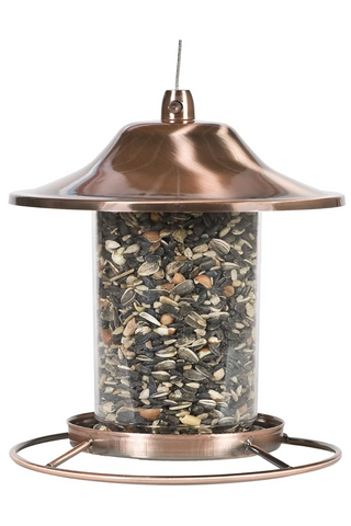 Bronze bird feeder filled with seeds on a white background