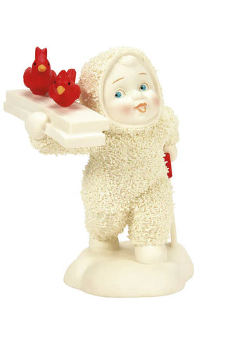 Decorative figurine of a child in a snowsuit holding red birds on a white background