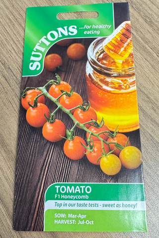 Suttons tomato seed packet on a wooden surface