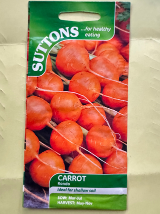 Suttons carrot seed packet on a beige background