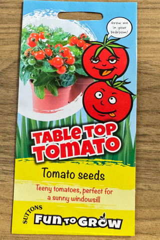 Package of Suttons Fun to Grow Table Top Tomato seeds on a wooden surface