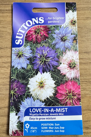 Suttons love-in-a-mist seed packet on a wooden surface
