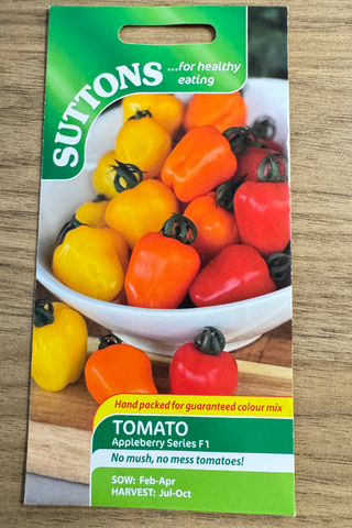 Suttons tomato seeds packet on a wooden surface