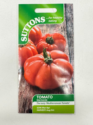 Suttons tomato seed packet with red tomatoes on a wooden surface