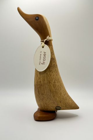 Wooden duck figurine with a tag on a white background