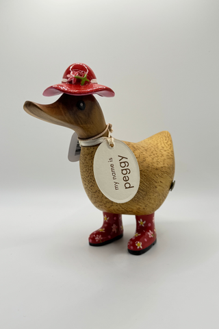 Toy duck with a red hat and floral boots on a white background