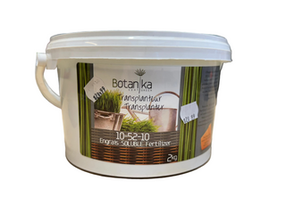 A white plastic bucket of Botanika brand transplanter fertilizer, with a label that includes product information and branding.