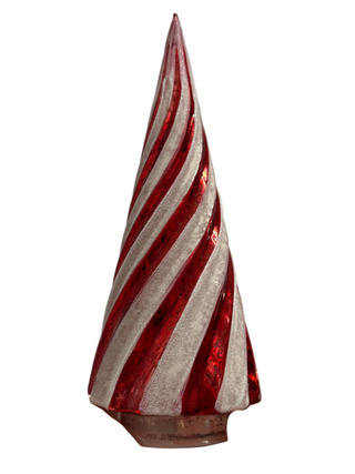 A hand holding a glass Christmas cone with red and white stripes and a pointed tip.