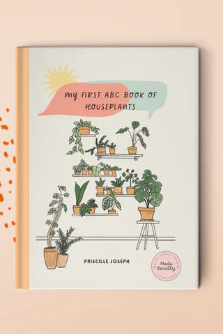 Book titled 'My First ABC Book of Houseplants' on a light pink background