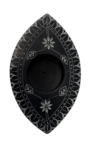 A black and white incense cone holder with an eye-shaped design and floral patterns.